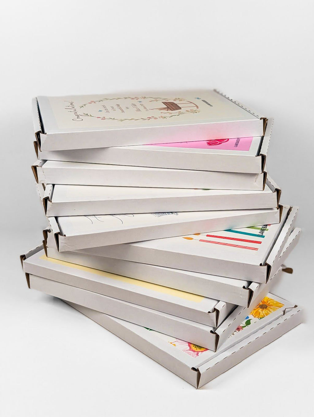 Stack of Cake Cards boxes featuring various celebration greeting card designs.